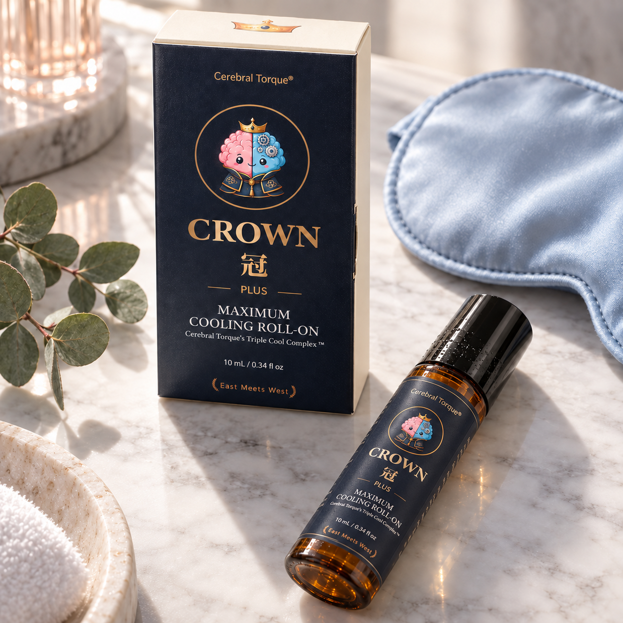 CROWN Plus cooling roll-on and box on a marble vanity with a silk eye mask and eucalyptus