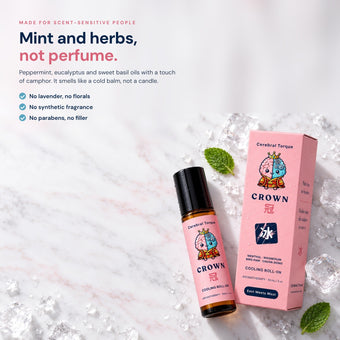 CROWN headache relief roll-on on white marble with mint and ice. Smells like mint and herbs, not perfume. No lavender, no synthetic fragrance, no parabens